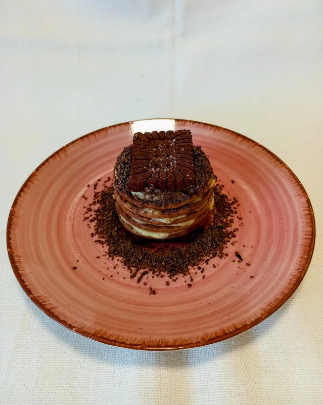 Bolo de bolacha nuvem inteiro com uma fatia cortada mostrando as camadas cremosas de creme mousseline francês e bolacha maria