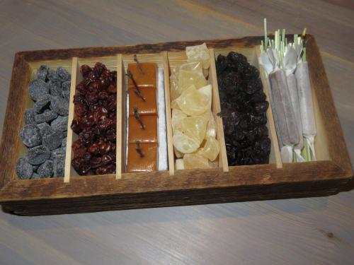 A wooden box filled with tar pastilles, dried rowanberries, smoked caramel, meadowsweet candy, dried black currants, sunflower seed nougat